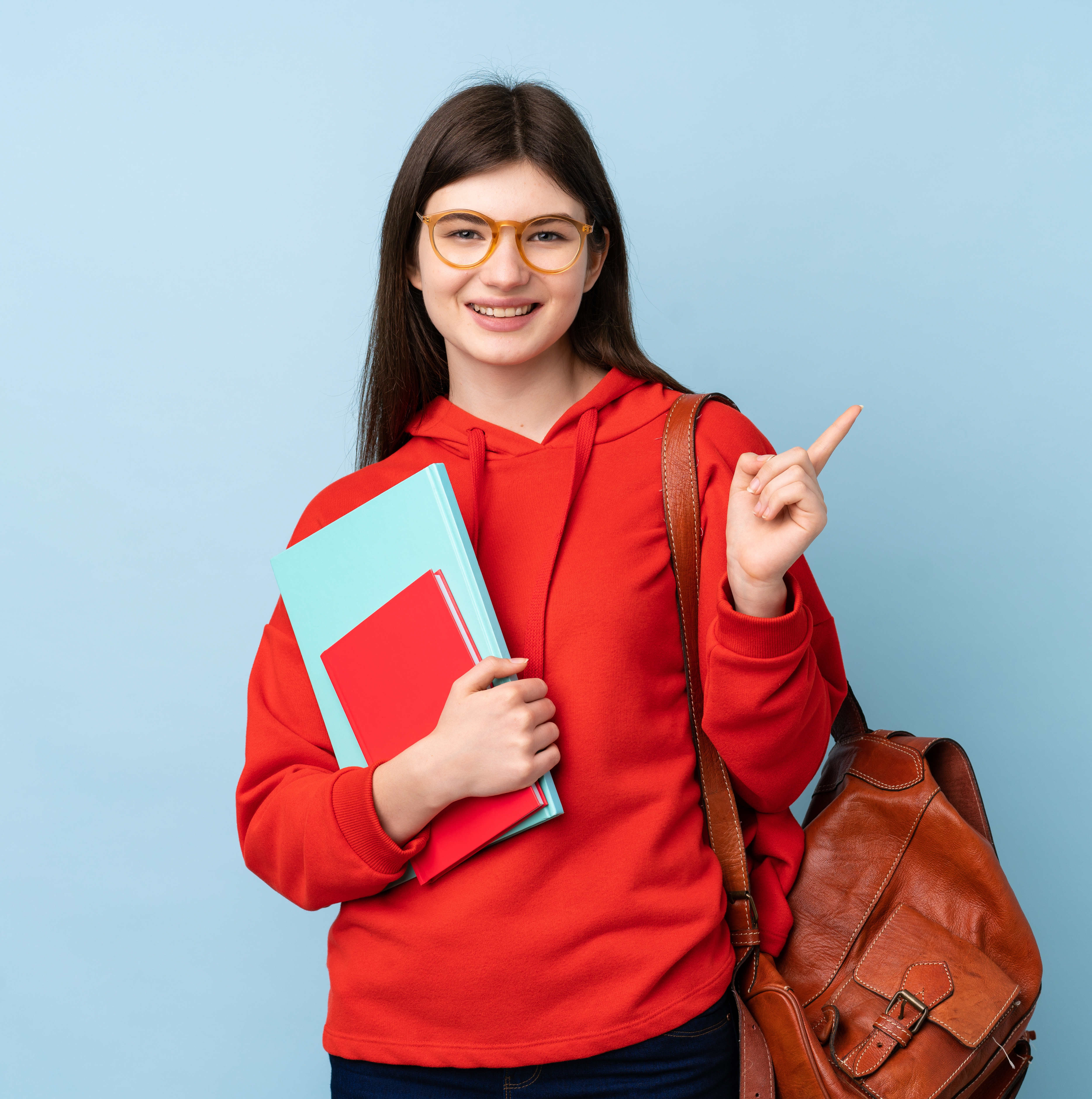 Young Ukrainian teenager student girl holding a salad over isolated blue background pointing finger to the side